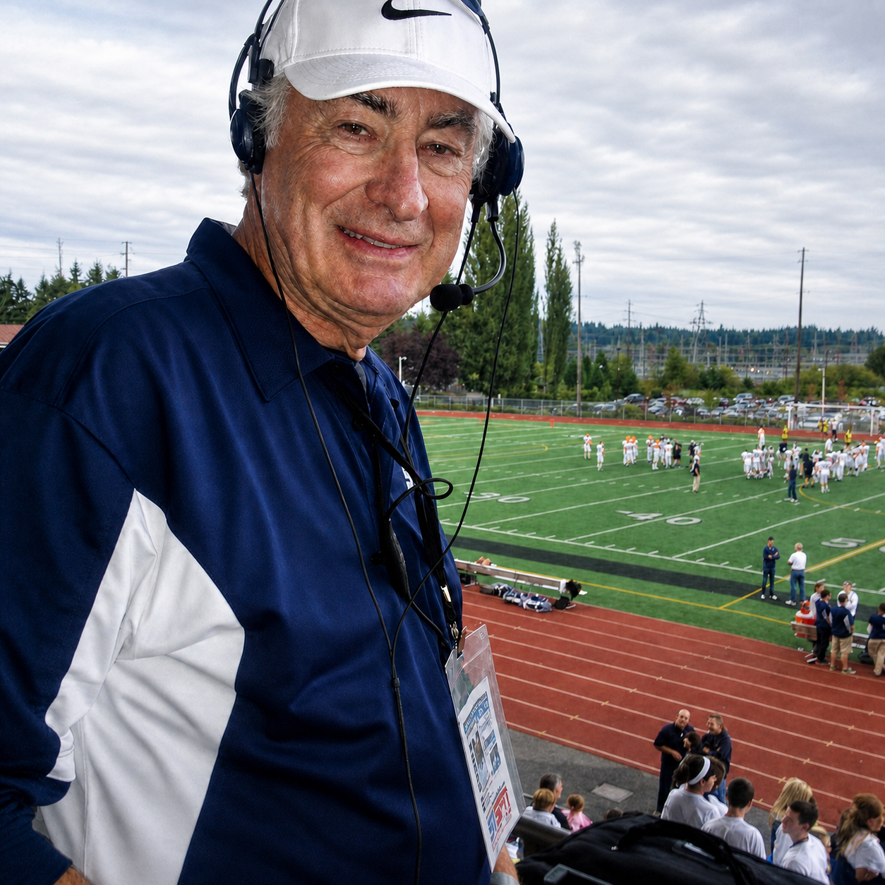 Ron Henthorn wearing a headset while broadcasting above a football field